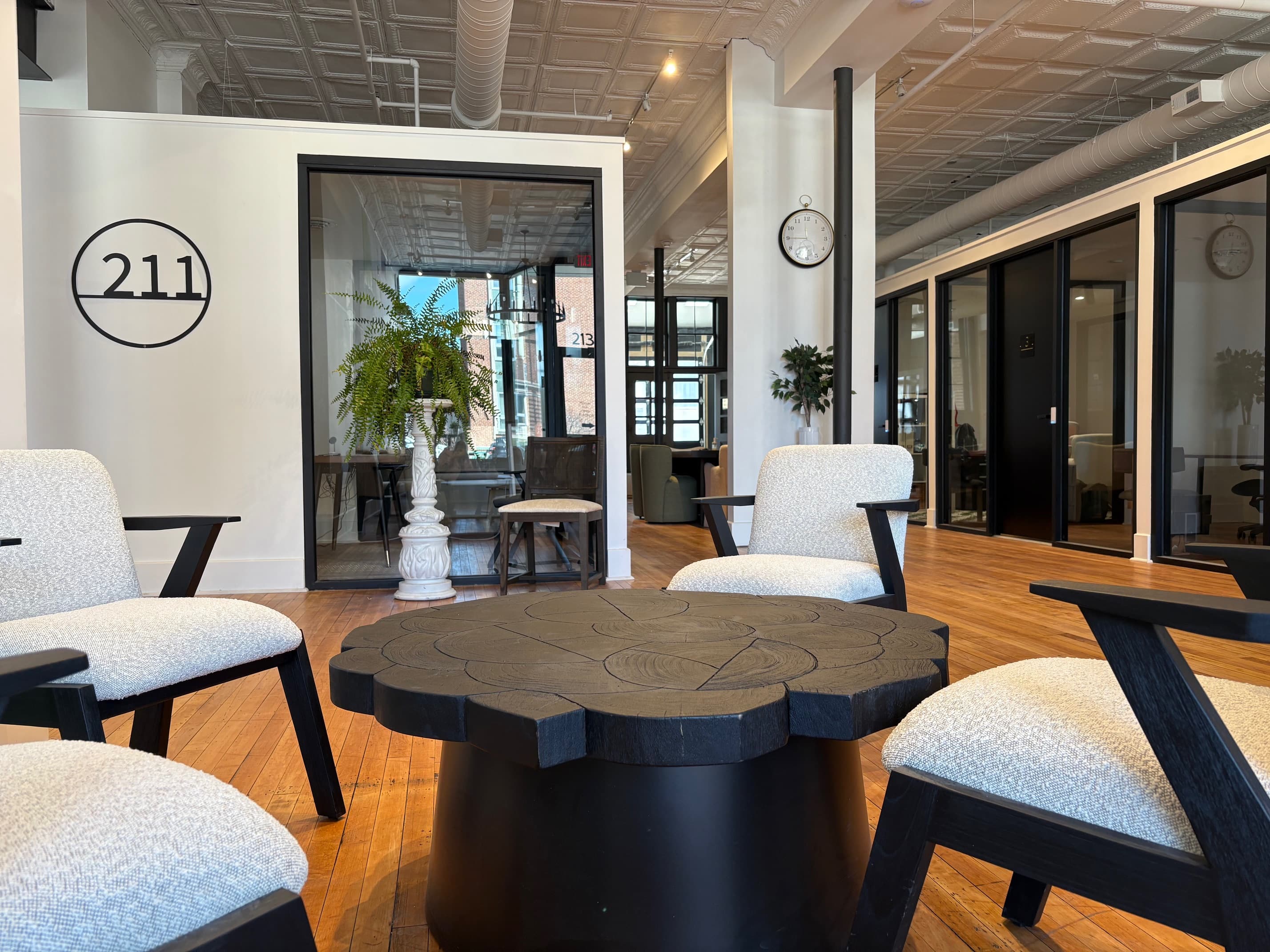 The Commons coworking area with 211 logo, modern seating, and private offices