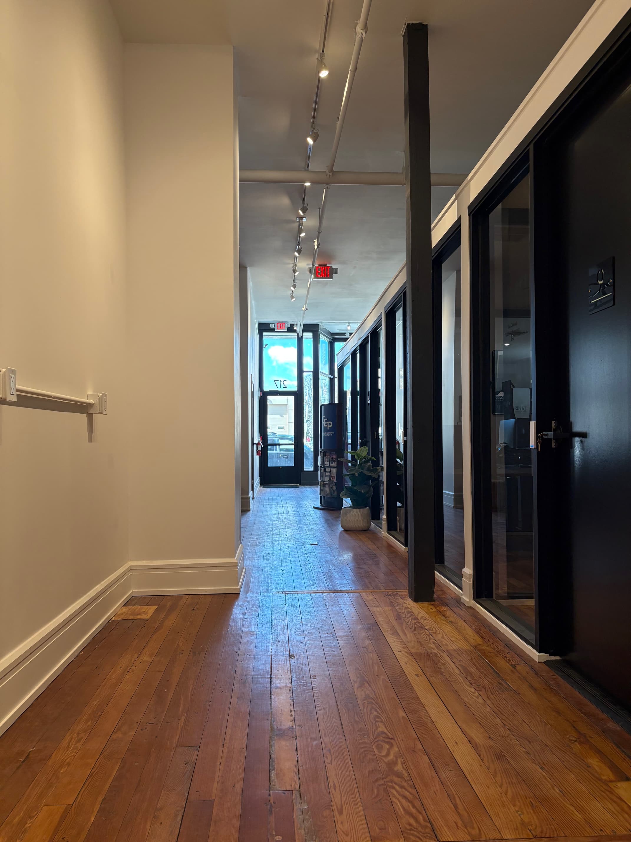 Private office suite with hardwood floors, track lighting, and natural light