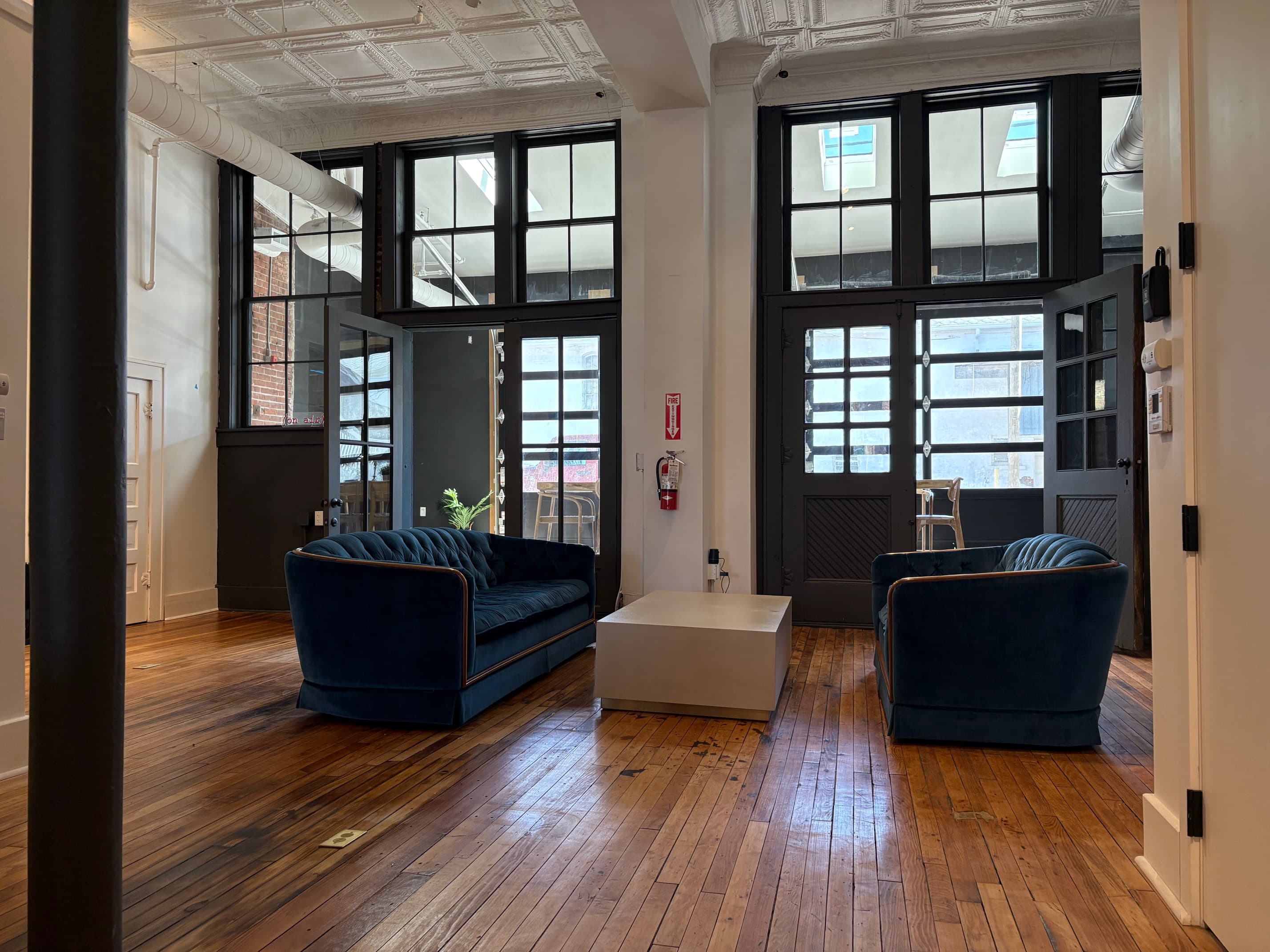 Lounge with navy velvet sofa and large windows