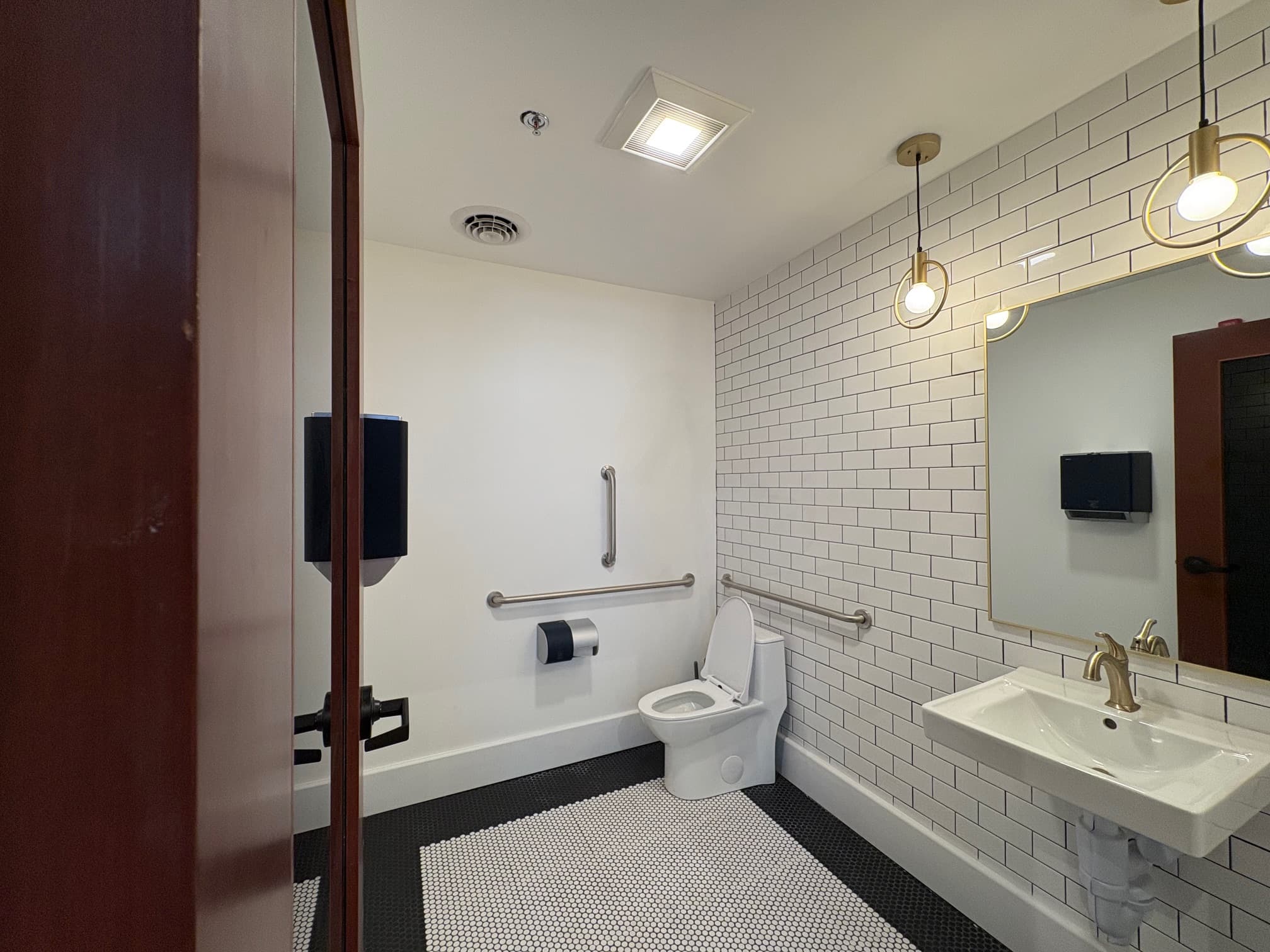 Restroom with subway tile and pendant lights